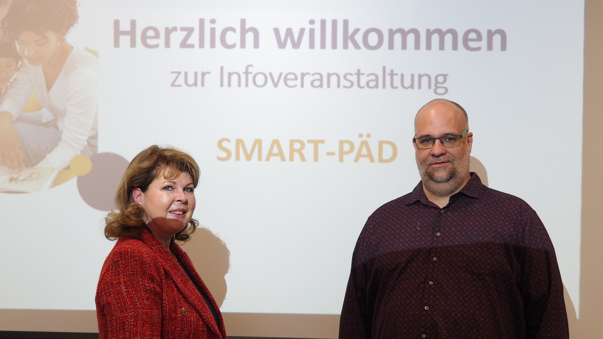 Abbildung zwei Personen vor einer Präsentationswand