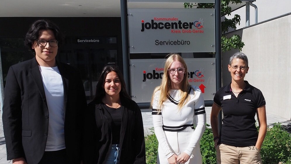 Ein Mann und drei Frauen stehen vor dem Gebäude des Jobcenters