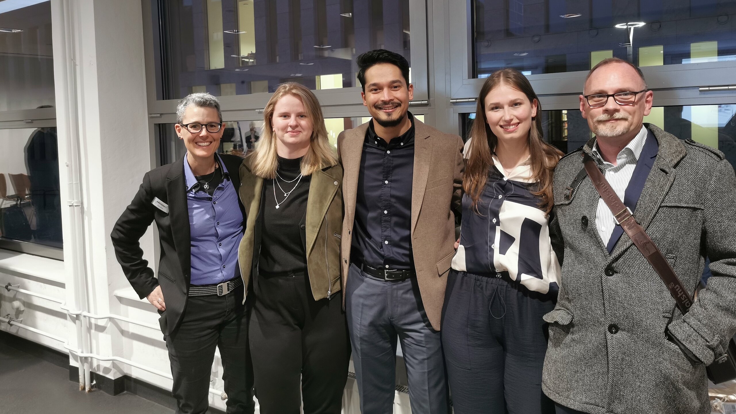 Abbildung fünf Personen vor einem Fenster